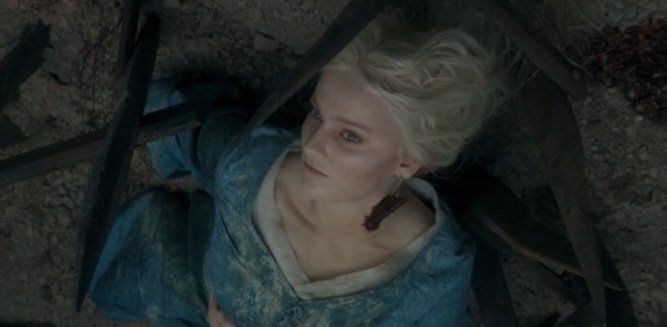 Overhead view of Phia Saban as Helaena Targaryen lying on the ground in a blue dress in House of the Dragon.