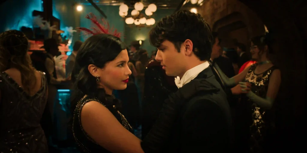 Nikki Rodriguez and Ashby Gentry dressed in 1920s vintage attire looking closely at each other at a formal event in My Life With the Walter Boys.