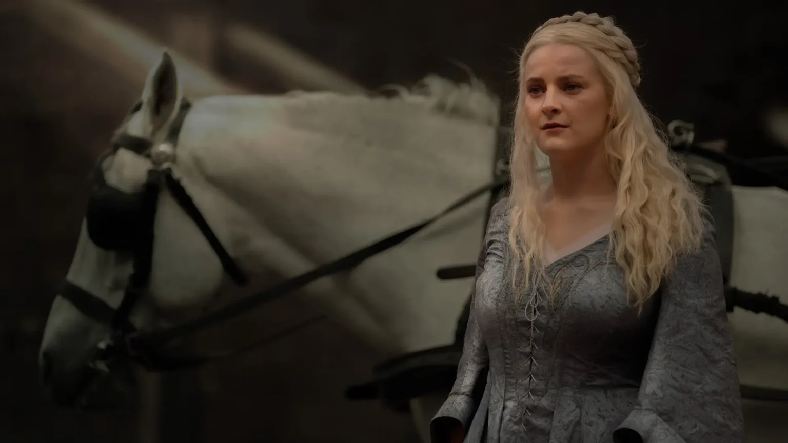 House of the Dragon Season 3: Explaining the Controversial Changes to Helaena Targaryen Phia Saban as Queen Helaena Targaryen wearing a grey patterned dress in front of a white horse in House of the Dragon.