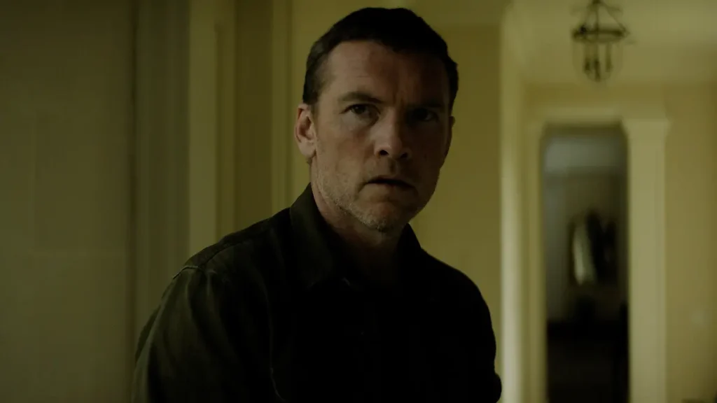 Sam Worthington looking stern and concerned in a hallway in Netflix's I Will Find You.