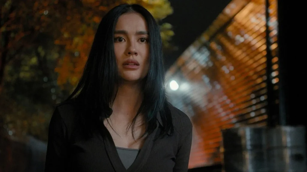 Lila Hoth standing outdoors at night with long dark hair and an anxious expression in Reacher Season 4.