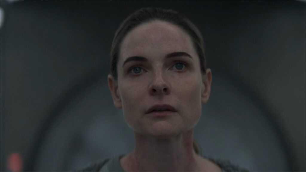 Close-up of Rebecca Ferguson with a somber, serious expression looking upward in Silo.