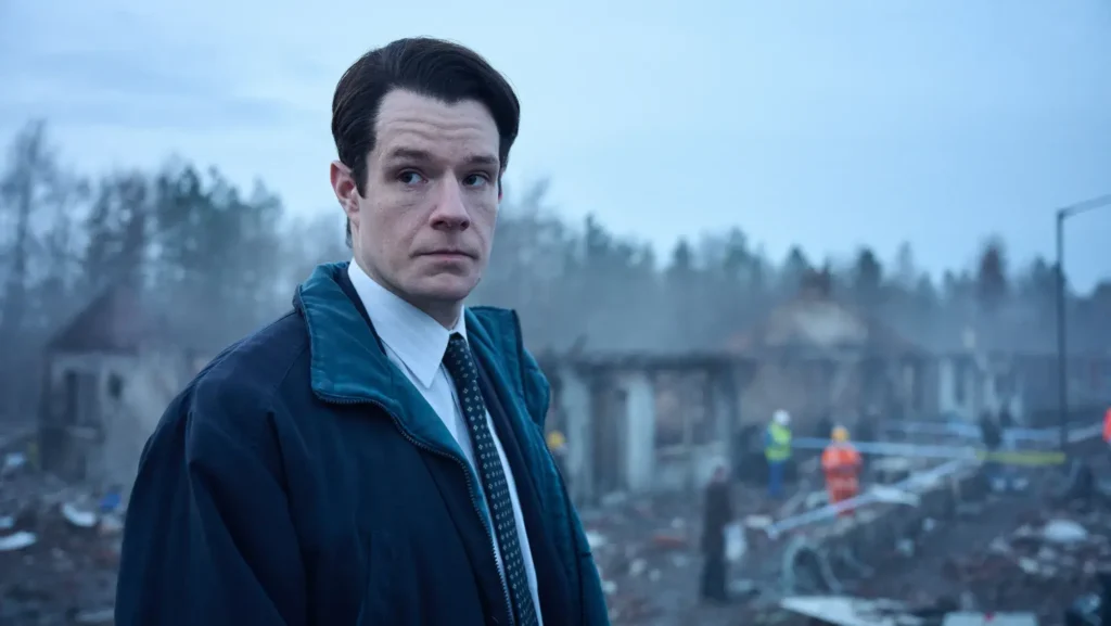 Connor Swindells as an investigator looking back at a destroyed disaster site in Netflix's The Bombing of Pan Am 103.